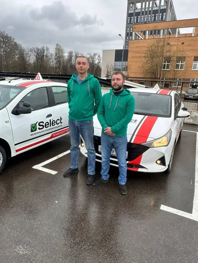 Двое инструкторов у учебных Renault Logan и Hyundai Solaris