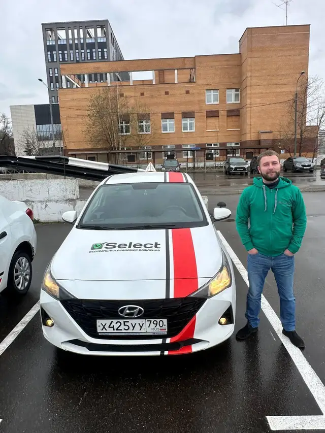 Сотрудник школы перед капотом Hyundai Solaris