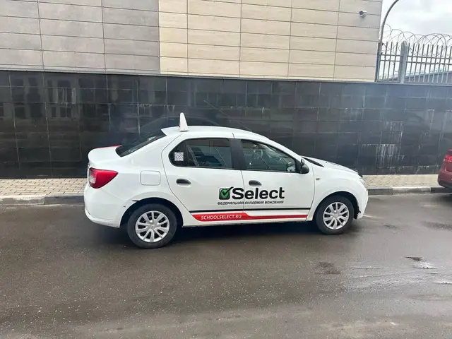 Renault Logan в профиль у административного здания