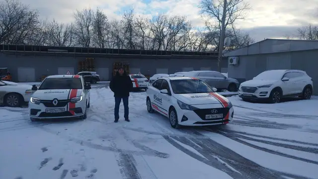 Наставник между двумя машинами на зимней парковке