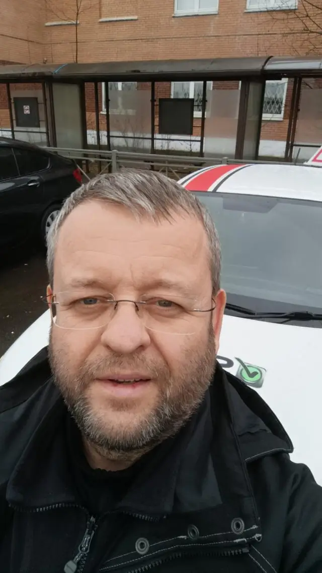 Инструктор по вождению рядом со своей машиной